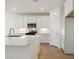 Modern kitchen features white cabinets, stainless steel appliances, and a center island at 15357 W Cottontail Ln, Surprise, AZ 85387