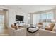 Bright living room with modern furniture, neutral color palette, and access to outdoor patio at 15357 W Cottontail Ln, Surprise, AZ 85387