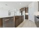 Modern kitchen island features a stainless steel dishwasher and sink with stylish faucet at 15365 W Cottontail Ln, Surprise, AZ 85387