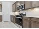 Modern kitchen features stainless steel appliances, quartz countertops, and wooden cabinets at 15429 W Cottontail Ln, Surprise, AZ 85387