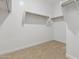 Walk-in closet featuring built-in shelving and ample storage space for an organized wardrobe at 15429 W Cottontail Ln, Surprise, AZ 85387