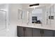 Bright bathroom boasts a dual sink vanity, tiled floors, and large mirror offering a clean and modern aesthetic at 1673 S 171St Dr, Goodyear, AZ 85338