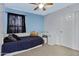 Bright bedroom features light blue walls, a ceiling fan, and natural light streaming through the curtains at 1673 S 171St Dr, Goodyear, AZ 85338