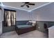 Neutral bedroom featuring string lights, a ceiling fan, and a bed with built-in drawers, complete with dark curtains at 1673 S 171St Dr, Goodyear, AZ 85338