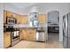 Spacious kitchen showcasing stainless steel appliances, granite countertops and seamless access to the living room at 1673 S 171St Dr, Goodyear, AZ 85338