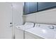 Functional laundry room with washer, dryer, and upper cabinets for organized storage solutions at 1673 S 171St Dr, Goodyear, AZ 85338