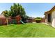 Lush backyard features a playground and artificial grass at 17937 W Westpark Blvd, Surprise, AZ 85388