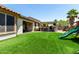 Backyard features lush artificial turf, covered patio, outdoor kitchen and a play structure at 17937 W Westpark Blvd, Surprise, AZ 85388