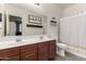 Bathroom features double sink vanity with framed mirror, decorative shelving and a shower-tub combination at 17937 W Westpark Blvd, Surprise, AZ 85388