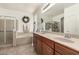 This bright bathroom has a double vanity sink, a bathtub, and a shower with a glass door at 17937 W Westpark Blvd, Surprise, AZ 85388