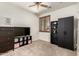 This bedroom includes a ceiling fan, a window with wood shutters, and a dark dresser and bookcase at 17937 W Westpark Blvd, Surprise, AZ 85388