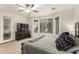 This bedroom features a bay window, a ceiling fan, and a dark dresser with a TV at 17937 W Westpark Blvd, Surprise, AZ 85388