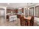 Well-lit kitchen with center island, granite countertops, dark wood cabinetry, and dining table at 17937 W Westpark Blvd, Surprise, AZ 85388
