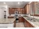 This home has an open kitchen with stainless appliances, granite counters and cherry cabinetry at 17937 W Westpark Blvd, Surprise, AZ 85388