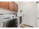 Bright laundry room with front loading washer and dryer and built-in upper cabinets at 17937 W Westpark Blvd, Surprise, AZ 85388