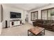 Bright and airy living room showcasing stylish furniture and a large screen TV at 17937 W Westpark Blvd, Surprise, AZ 85388