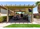 Outdoor kitchen under pergola, complete with grill, bar, and TV for entertaining at 17937 W Westpark Blvd, Surprise, AZ 85388