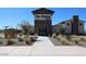 The front entry to the community clubhouse is landscaped with native grasses and shrubbery at 19195 N Los Gabrieles Way, Maricopa, AZ 85138