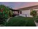 Landscaped backyard with artificial grass, covered patio, and ample space for outdoor enjoyment at 20858 E Sonoqui Dr, Queen Creek, AZ 85142