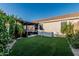 Lush backyard with covered patio, artificial grass, and easy access to outdoor living at 20858 E Sonoqui Dr, Queen Creek, AZ 85142