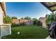 Well-maintained backyard with artificial turf, mature landscaping, and covered patio area at 20858 E Sonoqui Dr, Queen Creek, AZ 85142