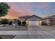 Charming home with desert landscaping, a tiled roof, and a two-car garage at sunset at 20858 E Sonoqui Dr, Queen Creek, AZ 85142