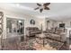Comfortable living room featuring wood floors, ceiling fan and sliding glass doors to the patio at 20858 E Sonoqui Dr, Queen Creek, AZ 85142