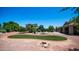 Beautiful backyard with lush landscaping, a sparkling pool, and an inviting firepit area at 2101 S 167Th Dr, Goodyear, AZ 85338