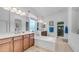 Bright bathroom with double sinks, a large tub, and tiled floors at 2101 S 167Th Dr, Goodyear, AZ 85338