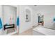 Bright bathroom with a walk in shower, a large tub, and neutral tile floors at 2101 S 167Th Dr, Goodyear, AZ 85338
