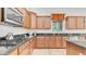 Kitchen featuring a gas stove, black countertops and custom wood cabinets with a complementing backsplash at 2101 S 167Th Dr, Goodyear, AZ 85338