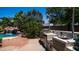 A complete outdoor kitchen and bar seating area overlooks a beautiful pool with waterfall feature at 2101 S 167Th Dr, Goodyear, AZ 85338