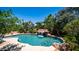 Beautiful pool with rock waterfall feature surrounded by lush landscaping and tropical plants at 2101 S 167Th Dr, Goodyear, AZ 85338