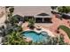 A stunning pool area is nestled amidst lush palm trees, a covered patio and an outdoor dining set at 2101 S 167Th Dr, Goodyear, AZ 85338