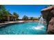 Inviting backyard oasis with a gorgeous pool, rock waterfall feature, and covered patio at 2101 S 167Th Dr, Goodyear, AZ 85338