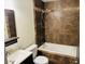 Bathroom featuring tile accents, sink, toilet, and tub with shower head at 2103 W Missouri Ave, Phoenix, AZ 85015