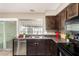 Traditional kitchen featuring dark cabinets, laminate counters and stainless steel dishwasher at 2645 W Elm St, Phoenix, AZ 85017