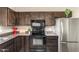 Close up of the kitchen featuring dark cabinets, modern black appliances, and updated counter tops at 2645 W Elm St, Phoenix, AZ 85017