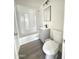 Updated bathroom with white fixtures, gray vanity, and a combined shower and tub at 2724 W Highland Ave, Phoenix, AZ 85017