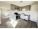 Modern kitchen with stainless steel appliances, light gray cabinets, white countertops, and gray wood-look floors at 2724 W Highland Ave, Phoenix, AZ 85017