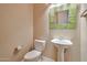 A small but stylish half bath featuring a pedestal sink, tile mirror, and a toilet at 3114 E Capricorn Way, Chandler, AZ 85249