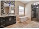 Updated bathroom featuring granite countertop, modern soaker tub, and mosaic tile backsplash at 3114 E Capricorn Way, Chandler, AZ 85249