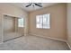 Bedroom with a ceiling fan, a mirrored closet, neutral carpet, and a window for natural light at 3114 E Capricorn Way, Chandler, AZ 85249