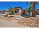 Single story home with desert landscaping featuring stone accents, a gated entry, and mature trees at 3114 E Capricorn Way, Chandler, AZ 85249