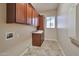 Laundry room featuring tiled floor, wooden cabinets and granite counters with a window for light at 3114 E Capricorn Way, Chandler, AZ 85249