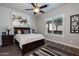Comfortable bedroom featuring a ceiling fan, modern art, and a window with plantation shutters at 31311 N 138Th Ave, Peoria, AZ 85383