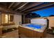 Hot tub with lit jets under a pergola, framed by a window and the brick perimeter wall at 31311 N 138Th Ave, Peoria, AZ 85383
