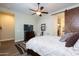 Bedroom featuring a barn door leading to the bathroom, and a decorative ceiling fan at 31311 N 138Th Ave, Peoria, AZ 85383