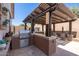 Outdoor kitchen with grill, pergola, and counter seating at 31311 N 138Th Ave, Peoria, AZ 85383