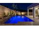 Relaxing backyard pool with waterfall feature and travertine tile under ambient lighting at 31311 N 138Th Ave, Peoria, AZ 85383